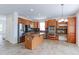 Spacious kitchen boasts wooden cabinets, stainless steel appliances, tile floors, and a center island with granite counters at 2631 E 136Th Pl, Thornton, CO 80602