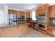 Well-equipped kitchen with stainless steel appliances, granite countertops, and custom wood cabinets at 2631 E 136Th Pl, Thornton, CO 80602
