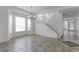 Bright living room boasting tiled floors, staircase, and ample natural light from large windows at 2631 E 136Th Pl, Thornton, CO 80602