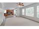 Bright living room with neutral carpet, ceiling fan, and view of the kitchen with wood cabinets and stainless appliances at 2631 E 136Th Pl, Thornton, CO 80602