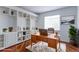 Home office with a desk, built-in bookshelves, hardwood floors, and a window that provides plenty of natural light at 2631 E 136Th Pl, Thornton, CO 80602