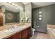 Elegant bathroom with double sinks, wood cabinets, and a soaking tub at 505 S Main St # 2207, Breckenridge, CO 80424