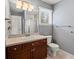 Cozy bathroom features wood vanity, neutral countertops, and shower with glass door at 5700 S Benton Cir, Littleton, CO 80123