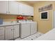 Functional laundry room with washer, dryer, sink, and storage cabinets at 5700 S Benton Cir, Littleton, CO 80123