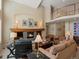 Expansive living room with a stone fireplace, vaulted ceiling, and natural light; ideal for gatherings and relaxation at 5700 S Benton Cir, Littleton, CO 80123