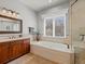 Inviting soaking tub with jets, next to a glass enclosed shower in a bright bathroom at 5700 S Benton Cir, Littleton, CO 80123