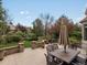 Outdoor patio with a dining area surrounded by green yard and mature trees at 5700 S Benton Cir, Littleton, CO 80123