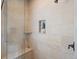 Large tiled shower with bench, built in shelves, and glass enclosure at 5700 S Benton Cir, Littleton, CO 80123