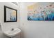 Contemporary bathroom with pedestal sink, elegant mirror, and charming floral artwork at 6240 Everett Ct # F, Arvada, CO 80004