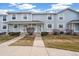 Charming townhome with light blue siding, white trim, a well-kept lawn, and a cozy front porch at 6240 Everett Ct # F, Arvada, CO 80004