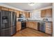 Well-lit kitchen features stainless steel appliances, wood cabinets, and hardwood floors at 6240 Everett Ct # F, Arvada, CO 80004