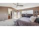 Bright primary bedroom featuring plush carpet, ceiling fan and ensuite bathroom at 6240 Everett Ct # F, Arvada, CO 80004