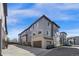 Modern townhome featuring a stylish gray and brick facade, multiple windows, and attached garages for convenient parking at 4265 E Iliff Ave # 1, Denver, CO 80222