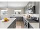 Well-lit kitchen with stainless steel appliances, sleek gray cabinets, and a marble island at 4265 E Iliff Ave # 1, Denver, CO 80222