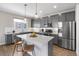 Stylish kitchen featuring gray cabinets, stainless appliances, and large quartz island with barstools at 4265 E Iliff Ave # 1, Denver, CO 80222