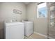 Well-lit laundry room equipped with washer, dryer, and shelving for ample storage at 4265 E Iliff Ave # 1, Denver, CO 80222