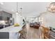 Open-concept living room showcasing kitchen island, dining area, and comfortable seating with hardwood floors at 4265 E Iliff Ave # 1, Denver, CO 80222