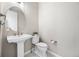 Chic powder room with pedestal sink, round mirror, and stylish herringbone tile flooring at 4265 E Iliff Ave # 1, Denver, CO 80222