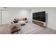 Stylish basement living area featuring a modern sectional sofa, area rug, and sleek TV stand at 5799 Boston St, Denver, CO 80238