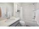 Bright bathroom featuring a white subway tile shower, gray vanity, and white fixtures for a clean aesthetic at 5799 Boston St, Denver, CO 80238