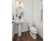 Elegant half bathroom features a pedestal sink, modern fixtures, and natural light from the window at 5799 Boston St, Denver, CO 80238