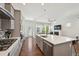 Bright kitchen with an island and open floor plan that leads to the living room with a fireplace at 5799 Boston St, Denver, CO 80238