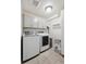 Functional laundry room with modern washer and dryer units, ample cabinet space, and tile flooring at 5799 Boston St, Denver, CO 80238