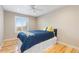 Cozy bedroom featuring light hardwood floors, a ceiling fan, and a window offering outdoor views at 3001 White Oak Trl, Highlands Ranch, CO 80129