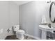 This powder room features modern fixtures, a pedestal sink, and stylish flooring at 3001 White Oak Trl, Highlands Ranch, CO 80129