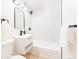 Modern bathroom featuring sleek vanity, black fixtures, tub with marble tile surround, and hardwood floors at 1361 W Custer Pl, Denver, CO 80223