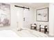 Bright bedroom featuring neutral tones, contemporary decor, and a sliding barn door at 1361 W Custer Pl, Denver, CO 80223