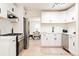Modern white kitchen with stainless steel appliances and view into dining area at 1361 W Custer Pl, Denver, CO 80223