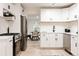 Modern kitchen with white cabinets, stainless steel appliances, and a view into the dining area at 1361 W Custer Pl, Denver, CO 80223