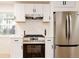 This well-lit kitchen features white cabinets, stainless steel appliances, and subway tile backsplash at 1361 W Custer Pl, Denver, CO 80223