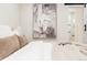 Bright bedroom with decorative art above the bed and a view to a modern ensuite bathroom at 1361 W Custer Pl, Denver, CO 80223