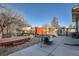 A backyard patio with table, bench, and rock landscaping creates an inviting outdoor space at 7611 Fernando Rd, Denver, CO 80221