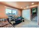 Living area with two sofas, carpet, a bright window, and a set of stairs at 7611 Fernando Rd, Denver, CO 80221