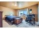 Bedroom featuring a bed, desk, and window offering natural light and street views at 7611 Fernando Rd, Denver, CO 80221