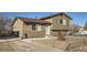 Exterior view featuring a two-story home with neutral siding and a gravel front yard at 7611 Fernando Rd, Denver, CO 80221