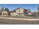 Exterior view featuring the home, detached garage, gravel front yard, and chain-link fence at 7611 Fernando Rd, Denver, CO 80221