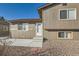 Exterior view of the home featuring a gravel yard, stone steps, and neutral siding at 7611 Fernando Rd, Denver, CO 80221