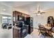 A kitchen with dark wood cabinets, black appliances, light floors, and a wooden table and chairs at 7611 Fernando Rd, Denver, CO 80221