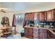 A kitchen featuring granite countertops, dark wood cabinetry, and stainless steel appliances under a window at 7611 Fernando Rd, Denver, CO 80221