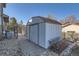 Exterior view of the backyard shed with a brick path, offering extra storage space at 7611 Fernando Rd, Denver, CO 80221