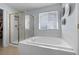 Bright bathroom with a tiled tub, shower with gold trim, and closet at 5010 Ox Trl, Parker, CO 80134