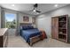 Cozy bedroom with ceiling fan, large window, wooden furniture, and neutral carpet at 5010 Ox Trl, Parker, CO 80134