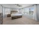 Spacious main bedroom with light blue walls, a ceiling fan, shutters, and a large bed with end tables at 5010 Ox Trl, Parker, CO 80134
