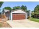 Charming single-story home featuring a large garage, well-maintained lawn, and colorful flower beds at 3735 S Lewiston St, Aurora, CO 80013