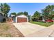 Charming single-story home featuring a large garage, well-maintained lawn, and colorful flower beds at 3735 S Lewiston St, Aurora, CO 80013