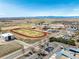 Aerial view of a school with a track, field, ample parking, and mountain views at 6707 6Th St, Frederick, CO 80530